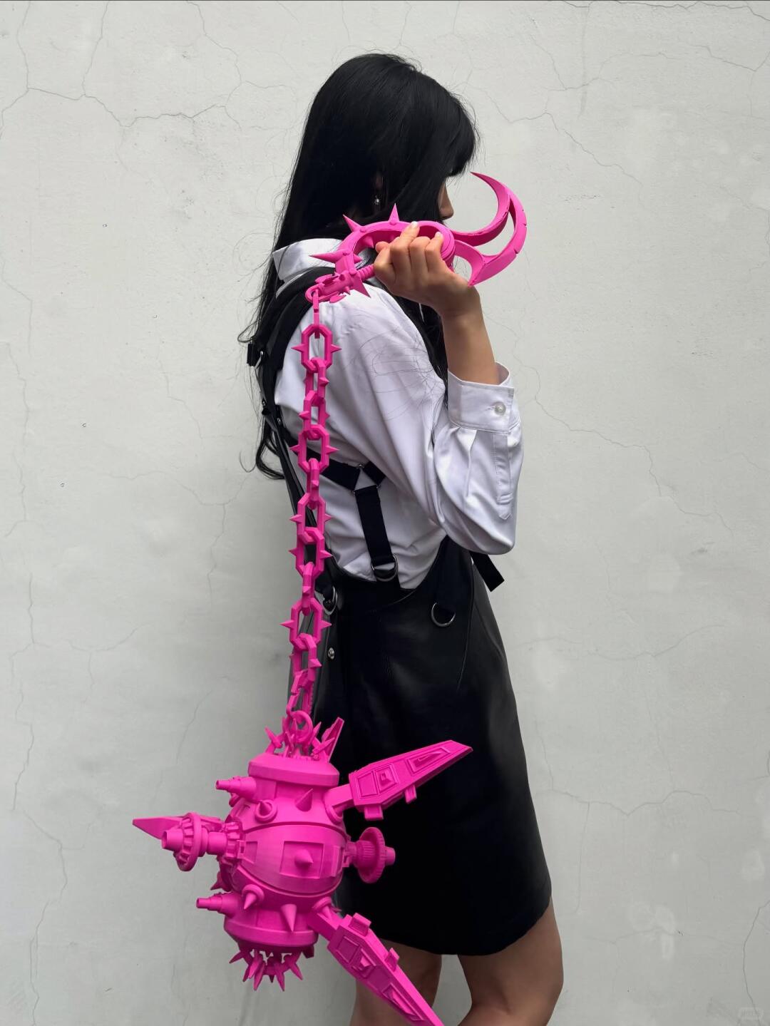 Pink spiked chain bag styled with a simple black-and-white outfit.