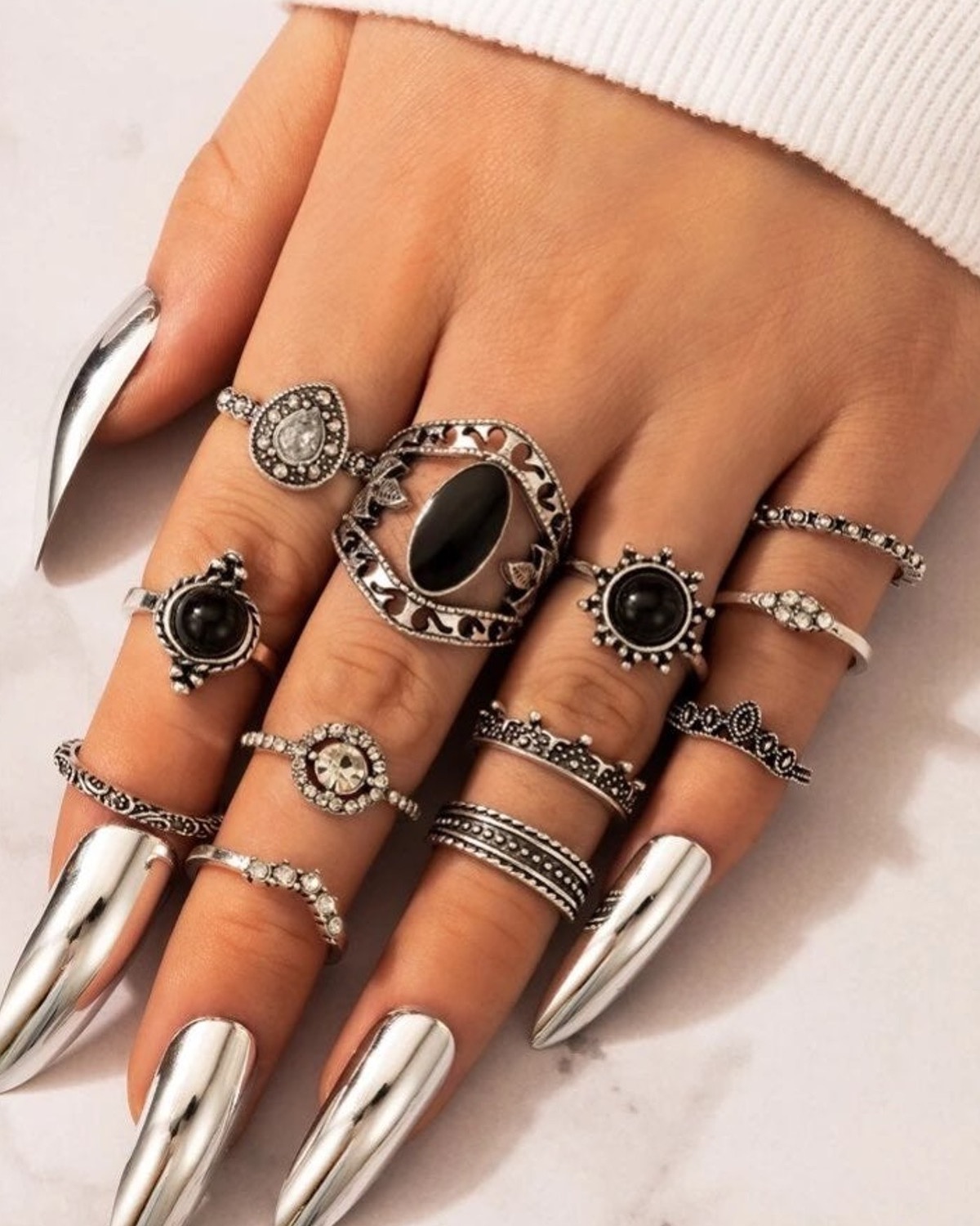 Chrome pointed nails surrounded by stacked silver-tone rings.